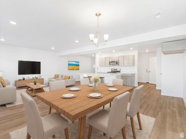 dining room featuring recessed lighting, light wood finished floors, and a chandelier