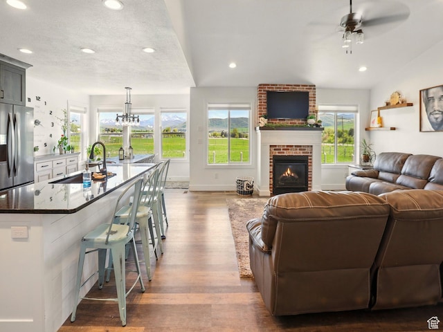 114 E 9500 S, Paradise, UT 84328 - living room featuring wood finished floors, ceiling fan, a brick fireplace, recessed lighting, and baseboards