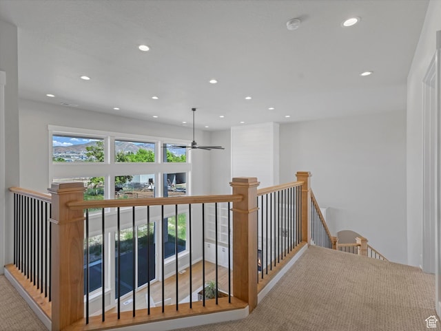 hallway featuring an upstairs landing, recessed lighting, and carpet flooring