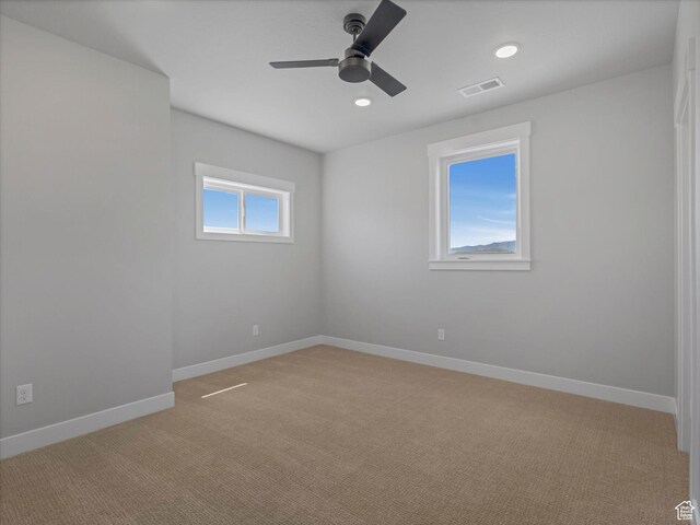 empty room featuring light carpet, ceiling fan, baseboards, and recessed lighting