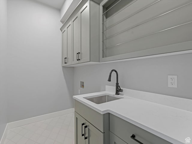 washroom with washer hookup, cabinet space, and baseboards