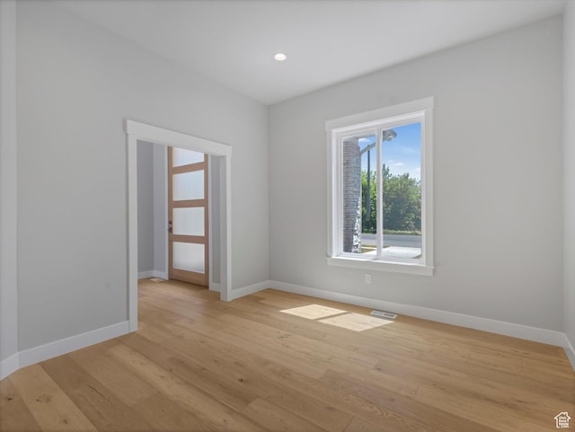spare room featuring baseboards, light wood-type flooring, and recessed lighting