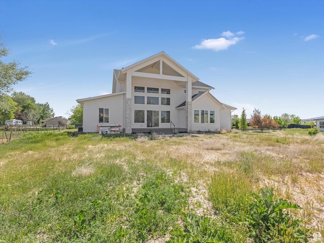 back of house featuring stucco siding and fence
