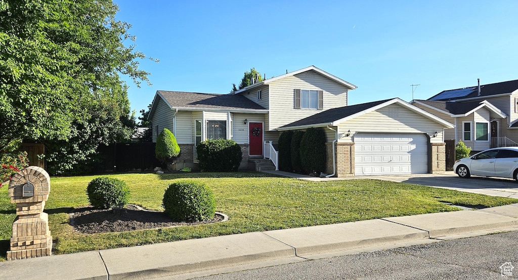 1429 W 600 N Street N, Pleasant Grove, UT 84062 - tri-level home featuring asphalt driveway, a garage, brick siding, a front yard, and entry steps