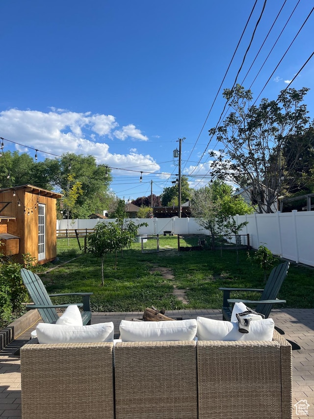 view of patio / terrace featuring outdoor lounge area, a shed, and an outdoor structure