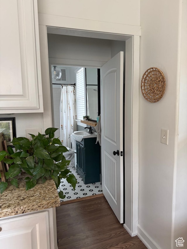 hallway featuring dark wood-style floors and baseboards