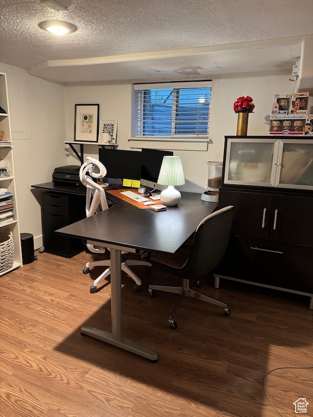 home office featuring a textured ceiling and wood finished floors