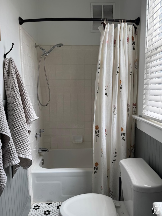 bathroom featuring shower / bath combo, toilet, and tile patterned flooring