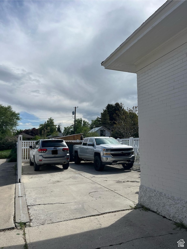 view of parking / parking lot featuring fence