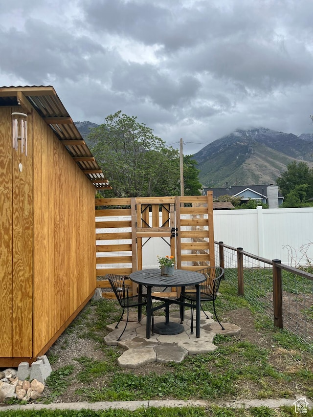 view of yard featuring a mountain view, fence, and outdoor dining area