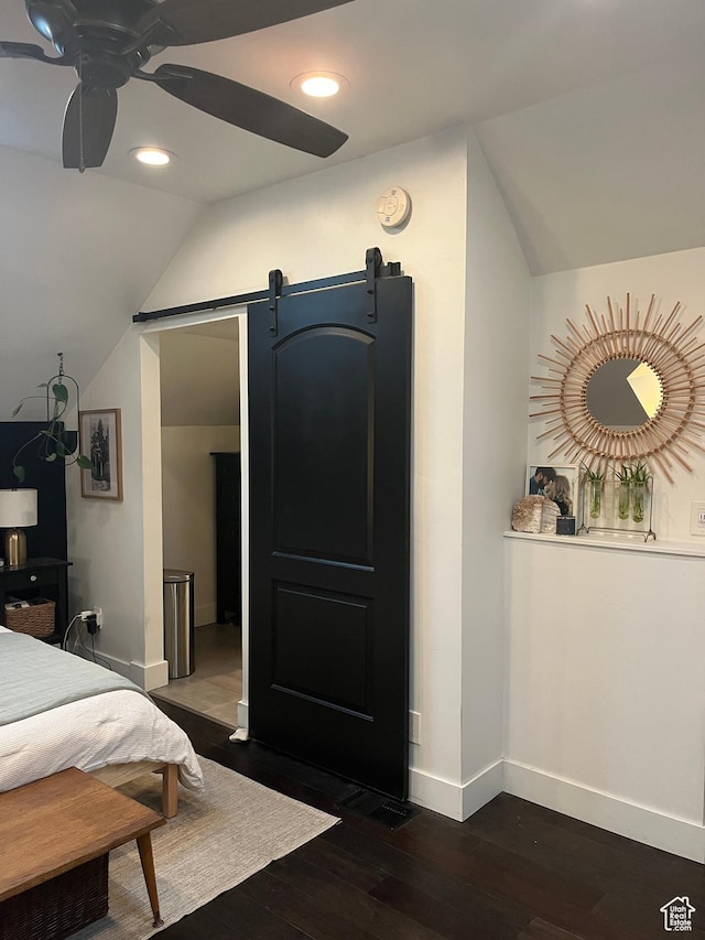 bedroom with vaulted ceiling, baseboards, a barn door, dark wood finished floors, and recessed lighting