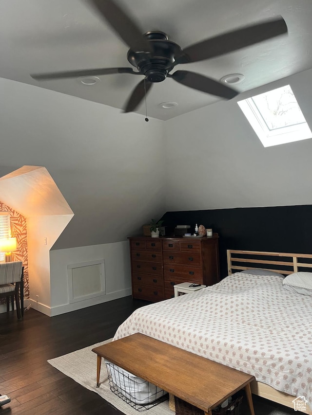 bedroom featuring vaulted ceiling, a skylight, wood finished floors, and baseboards