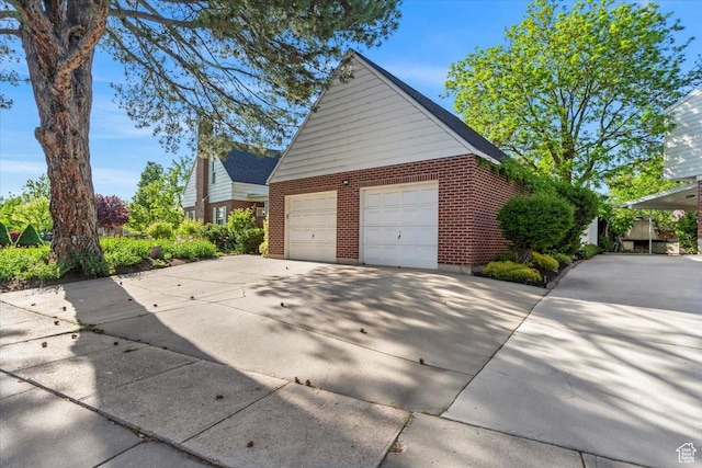 view of property exterior featuring brick siding and a garage
