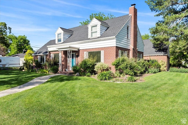 new england style home with brick siding, a front lawn, and a chimney
