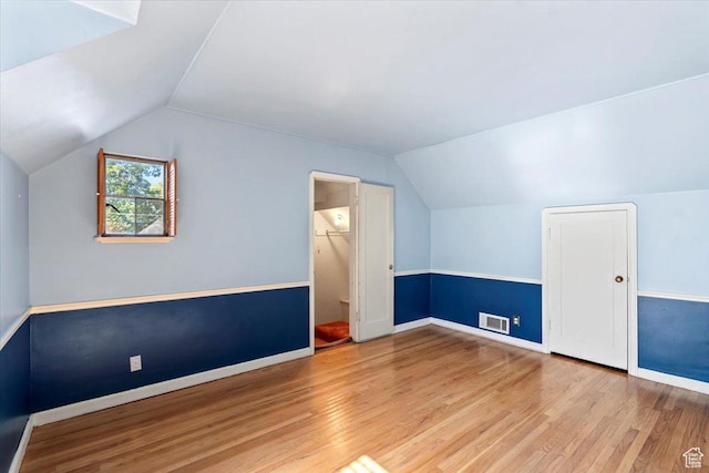 bonus room featuring lofted ceiling, wood finished floors, and baseboards