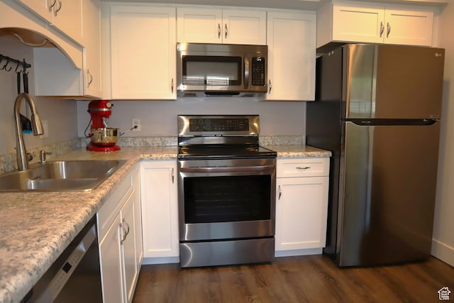 kitchen with stainless steel appliances, a sink, and white cabinets