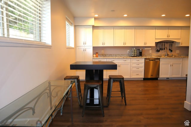 kitchen featuring stainless steel dishwasher, a sink, dark wood-style floors, white cabinets, and recessed lighting