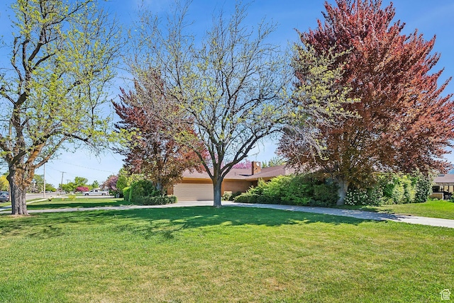 720 N 300 E, Tremonton, UT 84337 - view of property hidden behind natural elements with a front yard, an attached garage, and a chimney