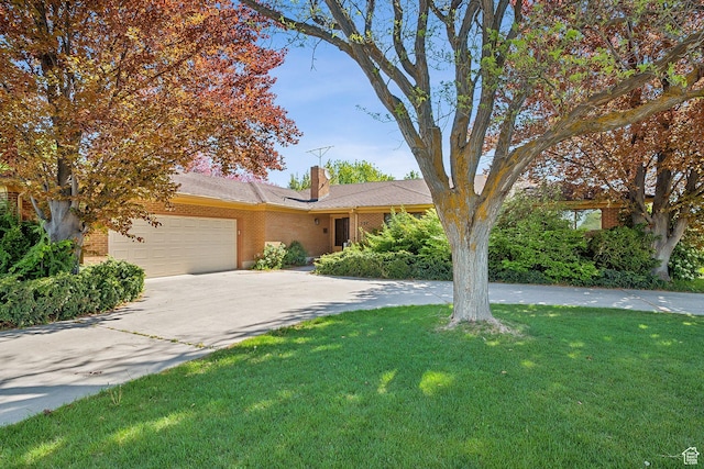 720 N 300 E, Tremonton, UT 84337 - view of front of house with an attached garage, brick siding, a front yard, and a chimney