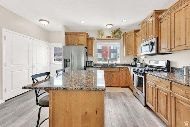 490 E 700 S Unit 514, Clearfield, UT 84015 - kitchen featuring appliances with stainless steel finishes, a kitchen breakfast bar, a sink, light wood finished floors, and recessed lighting