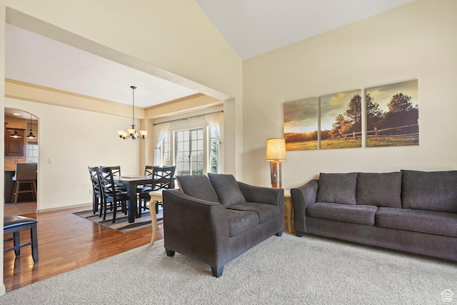 8127 S Bear Lake Ct, West Jordan, UT 84081 - living area with a chandelier, arched walkways, wood finished floors, vaulted ceiling, and carpet floors
