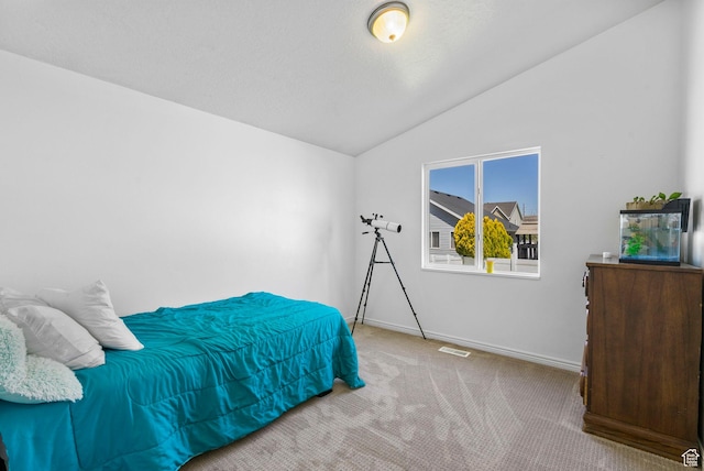 bedroom with vaulted ceiling, carpet flooring, and baseboards