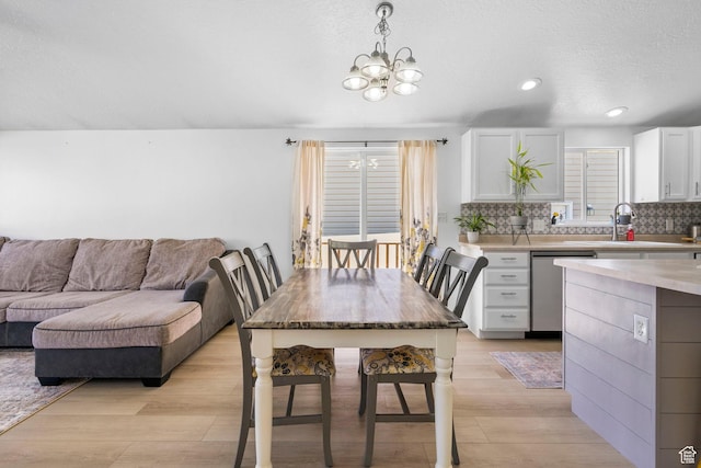 dining area with a chandelier, light wood-type flooring, and recessed lighting