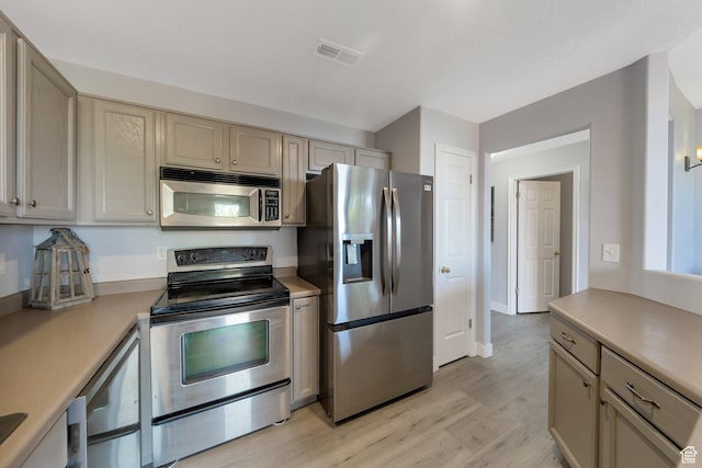 175 E Wayfield Dr S, Draper, UT 84020 - kitchen featuring appliances with stainless steel finishes, light countertops, light wood-type flooring, and cream cabinetry