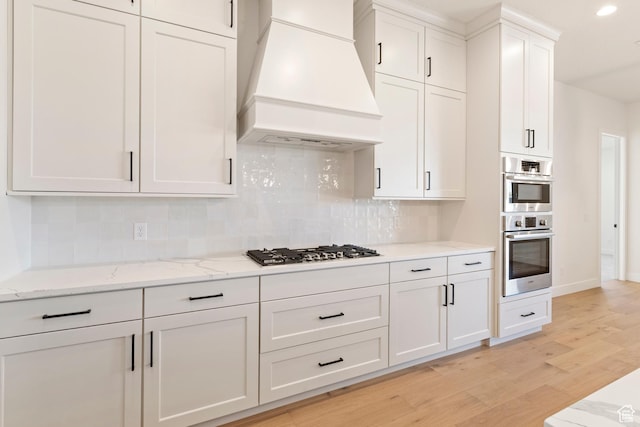 4845 W 2020 S, Hurricane, UT 84737 - kitchen featuring premium range hood, appliances with stainless steel finishes, light wood-type flooring, decorative backsplash, and recessed lighting