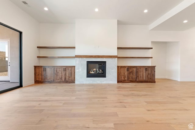 4845 W 2020 S, Hurricane, UT 84737 - unfurnished living room featuring light wood-style flooring, recessed lighting, a glass covered fireplace, and baseboards
