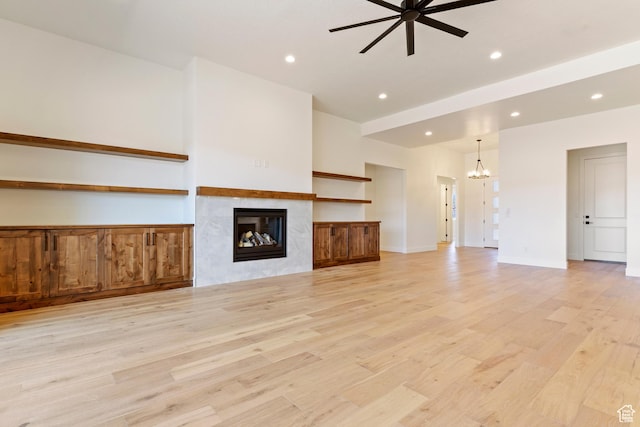 4845 W 2020 S, Hurricane, UT 84737 - unfurnished living room with a chandelier, a ceiling fan, light wood-style flooring, recessed lighting, and a high end fireplace
