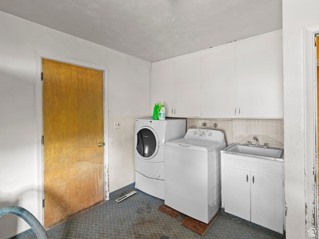 10045 W 12000 N, Bothwell, UT 84337 - laundry room featuring washing machine and dryer, cabinet space, tile walls, and dark tile patterned flooring