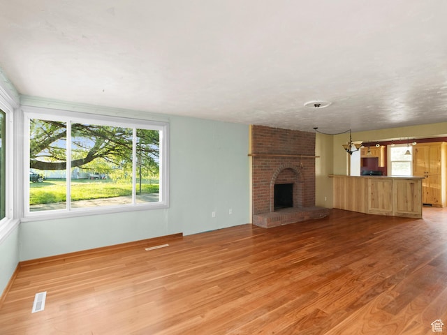 10045 W 12000 N, Bothwell, UT 84337 - unfurnished living room featuring light wood finished floors and a fireplace