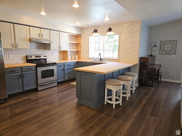 kitchen with wooden counters, appliances with stainless steel finishes, under cabinet range hood, gray cabinetry, and recessed lighting
