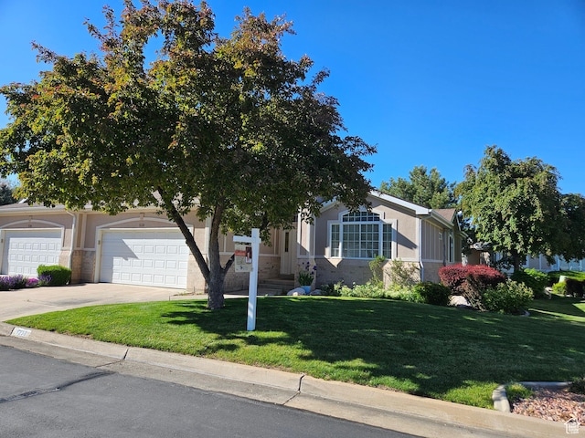 obstructed view of property with driveway, a front lawn, stucco siding, and an attached garage