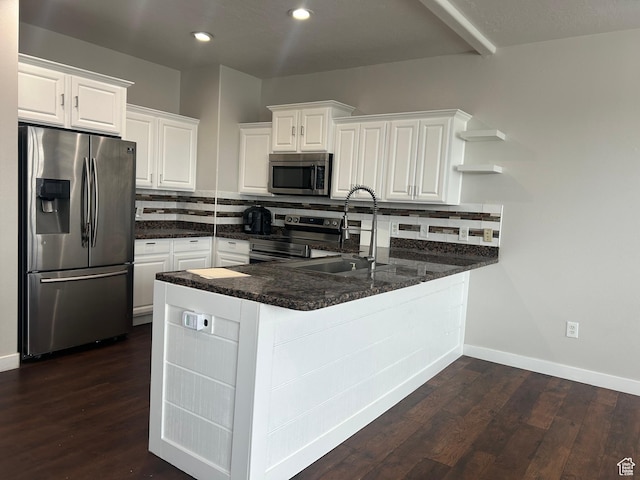 kitchen featuring stainless steel appliances, a sink, open shelves, a peninsula, and white cabinets
