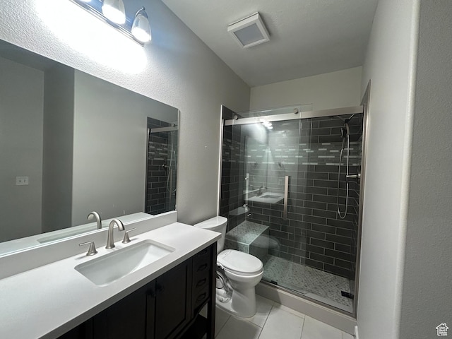 bathroom with toilet, tile patterned flooring, a stall shower, and vanity