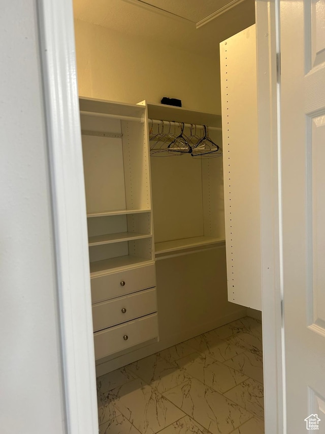 walk in closet with light marble finish flooring
