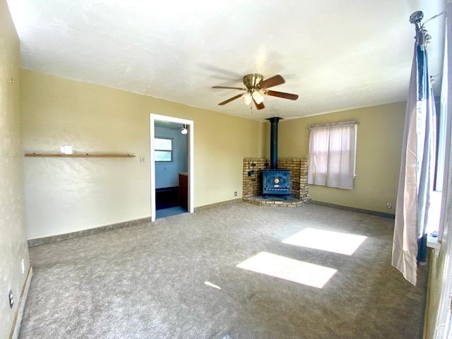 271 S Court St W, Soda Springs, ID 83276 - unfurnished living room with a wood stove, carpet, ceiling fan, and baseboards