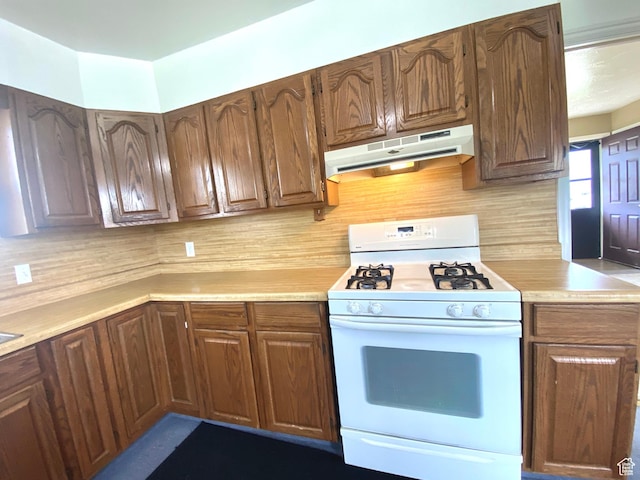 271 S Court St W, Soda Springs, ID 83276 - kitchen featuring white gas stove, under cabinet range hood, light countertops, and backsplash