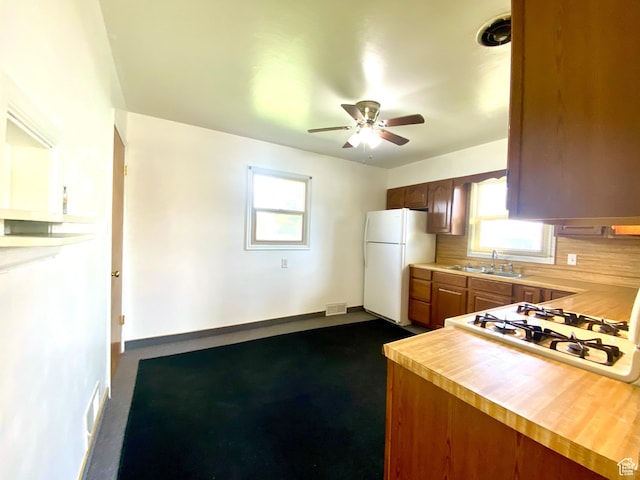 271 S Court St W, Soda Springs, ID 83276 - kitchen with freestanding refrigerator, a sink, a ceiling fan, stovetop, and backsplash
