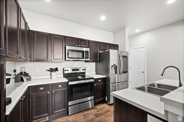 6616 W 7735 S, West Jordan, UT 84081 - kitchen with stainless steel appliances, a sink, dark wood finished floors, dark brown cabinets, and recessed lighting
