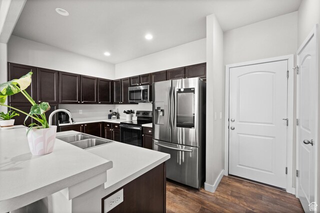 6616 W 7735 S, West Jordan, UT 84081 - kitchen with appliances with stainless steel finishes, a sink, dark brown cabinets, dark wood-style floors, and light countertops