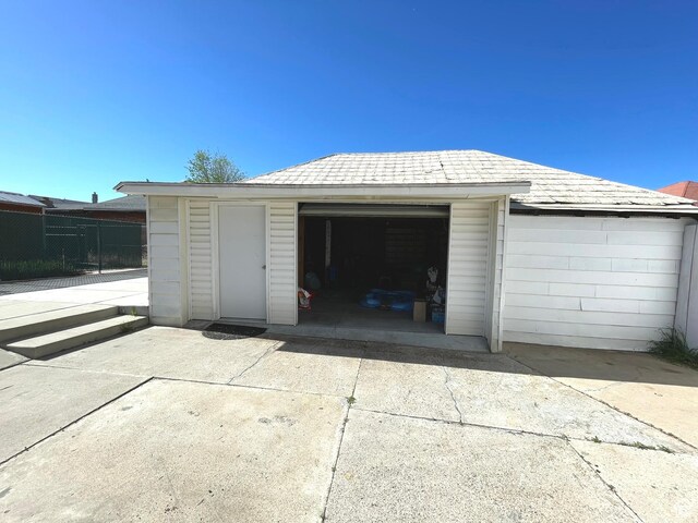 detached garage with fence and driveway