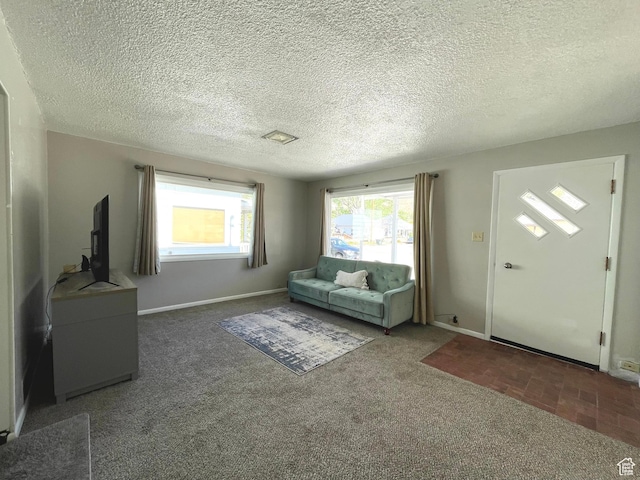 living area with carpet floors, a textured ceiling, and baseboards