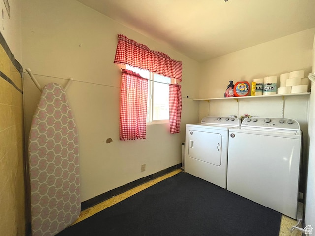 clothes washing area with washing machine and clothes dryer and baseboards