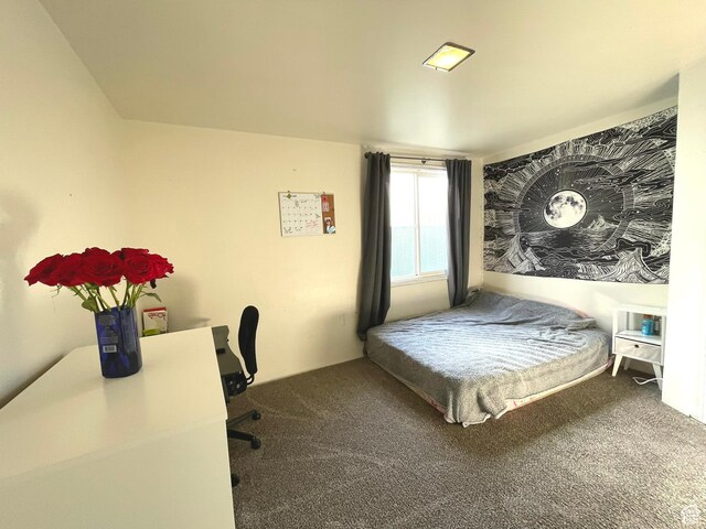 carpeted bedroom with a desk