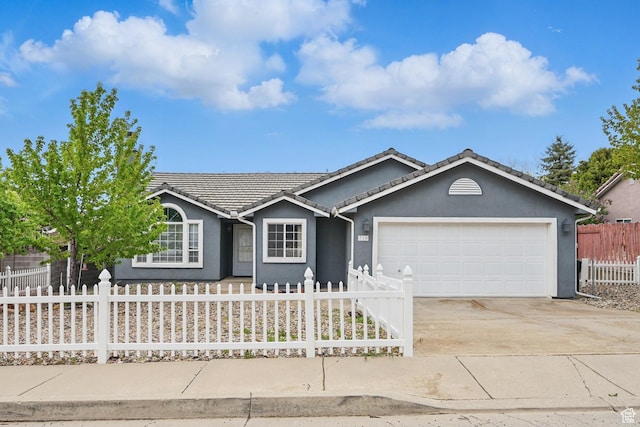 710 W 1350 S, Cedar City, UT 84720 - ranch-style house with a fenced front yard, a garage, concrete driveway, stucco siding, and a tiled roof