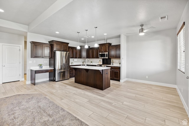 3335 W 2570 S, Hurricane, UT 84737 - kitchen featuring appliances with stainless steel finishes, a breakfast bar, light countertops, baseboards, and dark brown cabinets