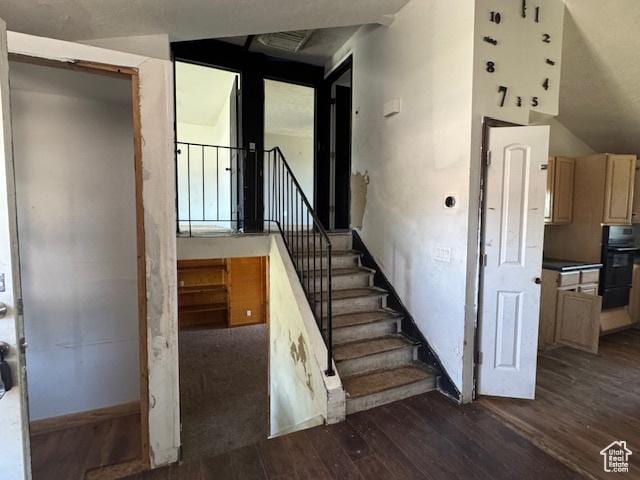 stairway featuring wood finished floors and baseboards